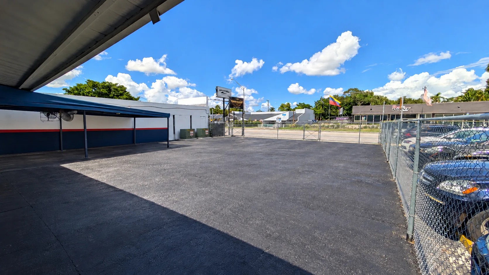Fenced, paved outdoor lot of the West section with the business sign visible on NE 79th St.